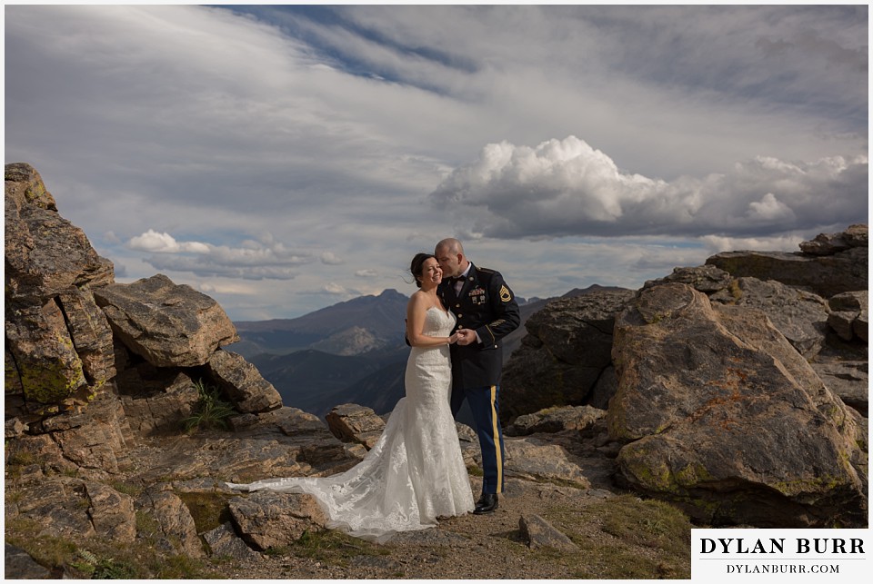 rocky mountain national park wedding bride and groom snuggling on top of the mountains in the sunlight