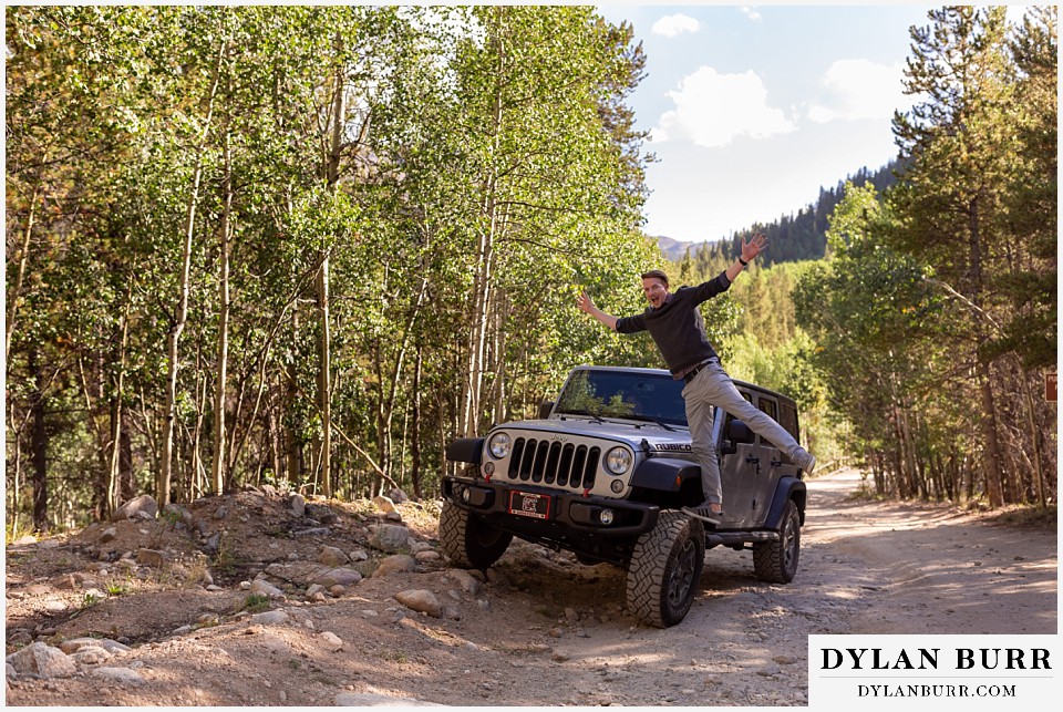 colorado mountain enagagement photos standing up on jeep tire in middle of trail
