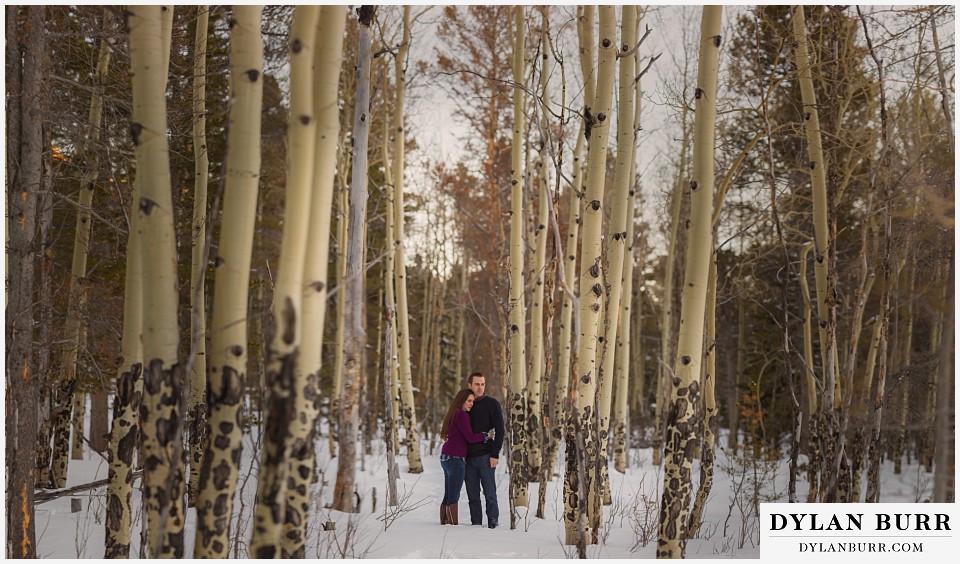 how to prepare for my engagement session couple standing in snow in aspen trees