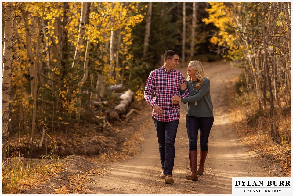 how to prepare for my engagement session couple walking together on road in the fall