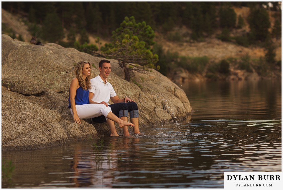 how to prepare for my engagement session couple sitting on rock near lake playing in water