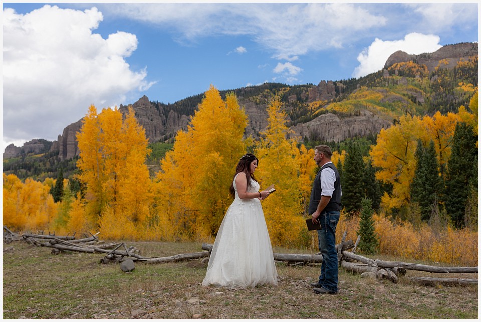 adventure elopement western colorado bride reading vows in mountain meadow