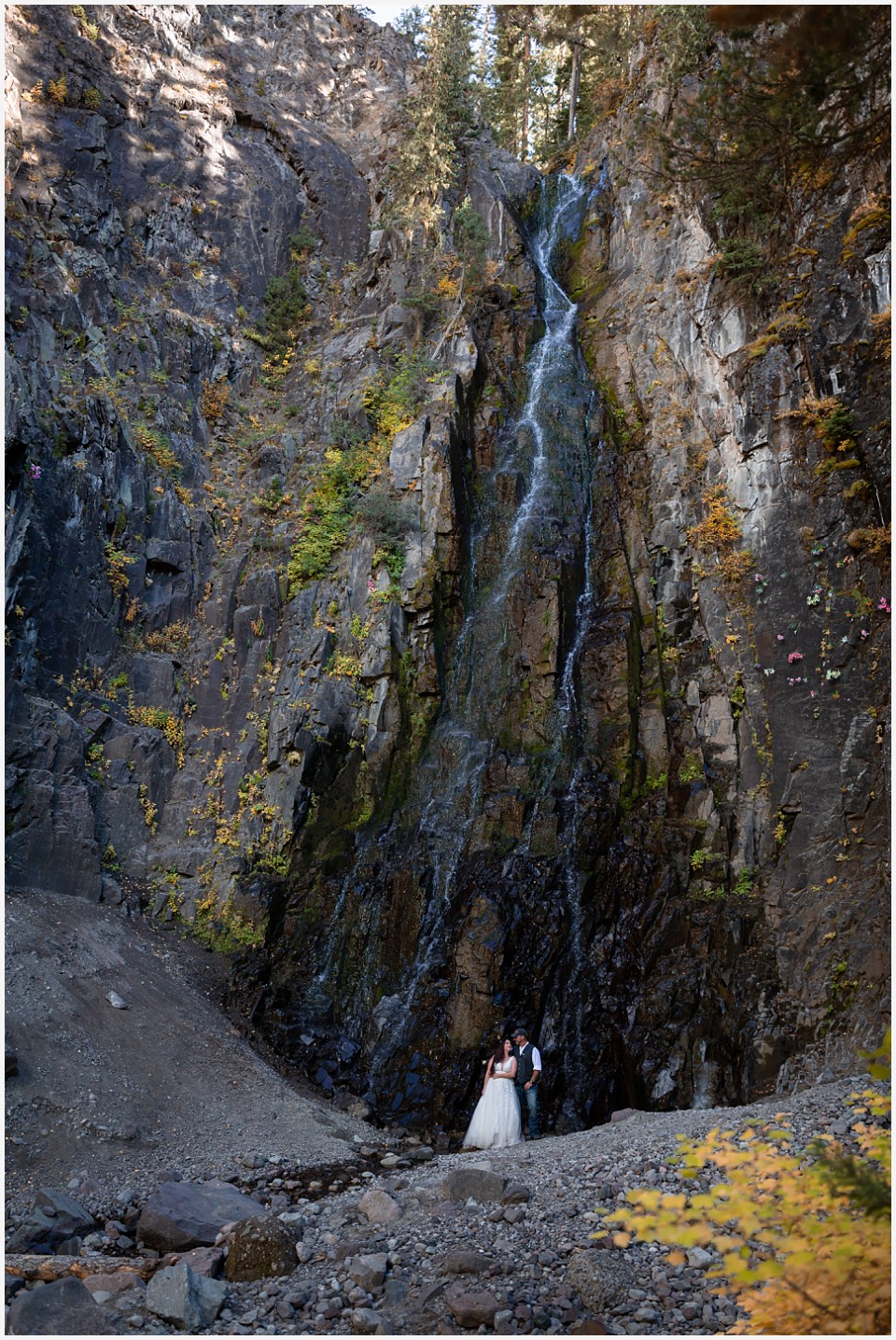 adventure elopement western colorado couple standing by a giant waterfall