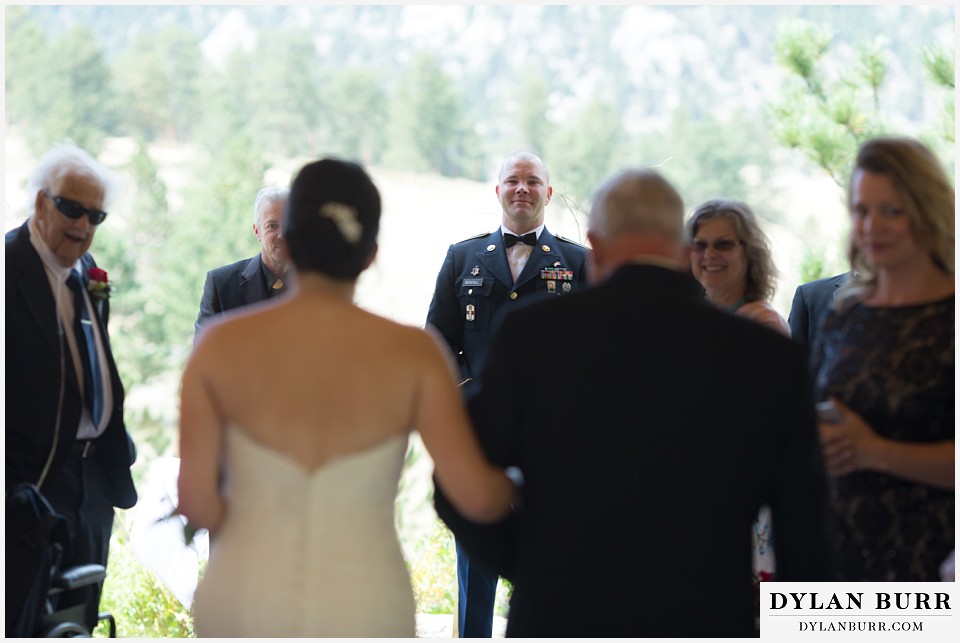 black canyon inn wedding estes park colorado groom watches as bride and her father walk down aisle