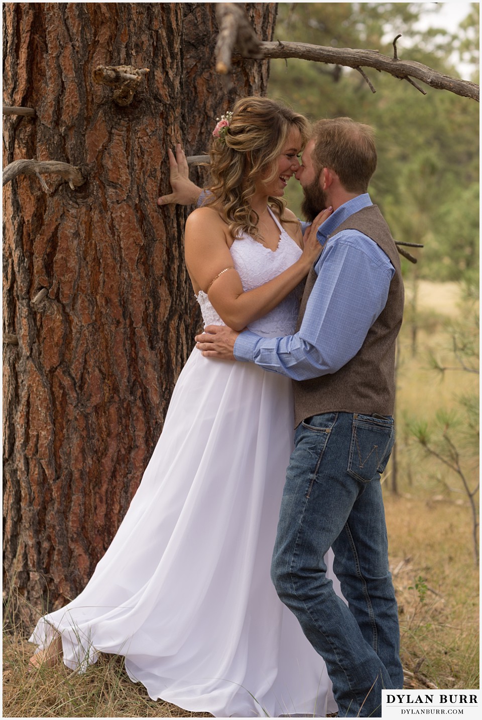 boho backyard colorado wedding bride and groom sharing a kiss near a pine tree