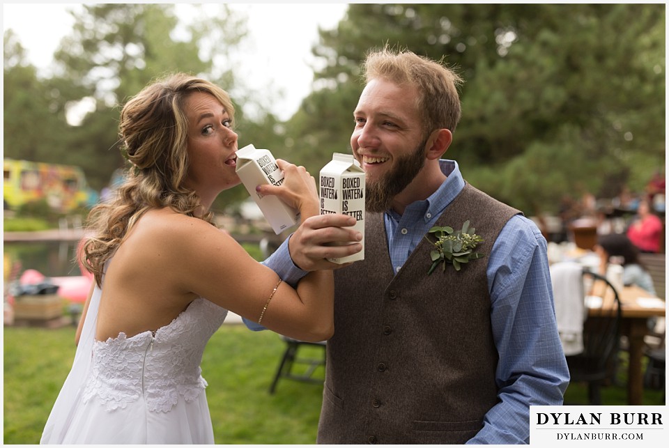 boho backyard colorado wedding bride and groom drinking boxed water