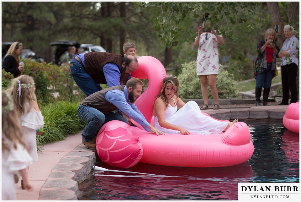 boho backyard colorado wedding bride and  groom getting on flamingo float