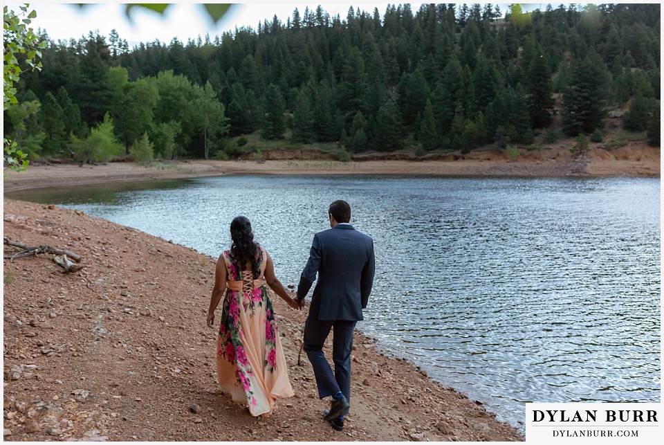 boulder colorado engagement session in the mountains couple walking together along the lake
