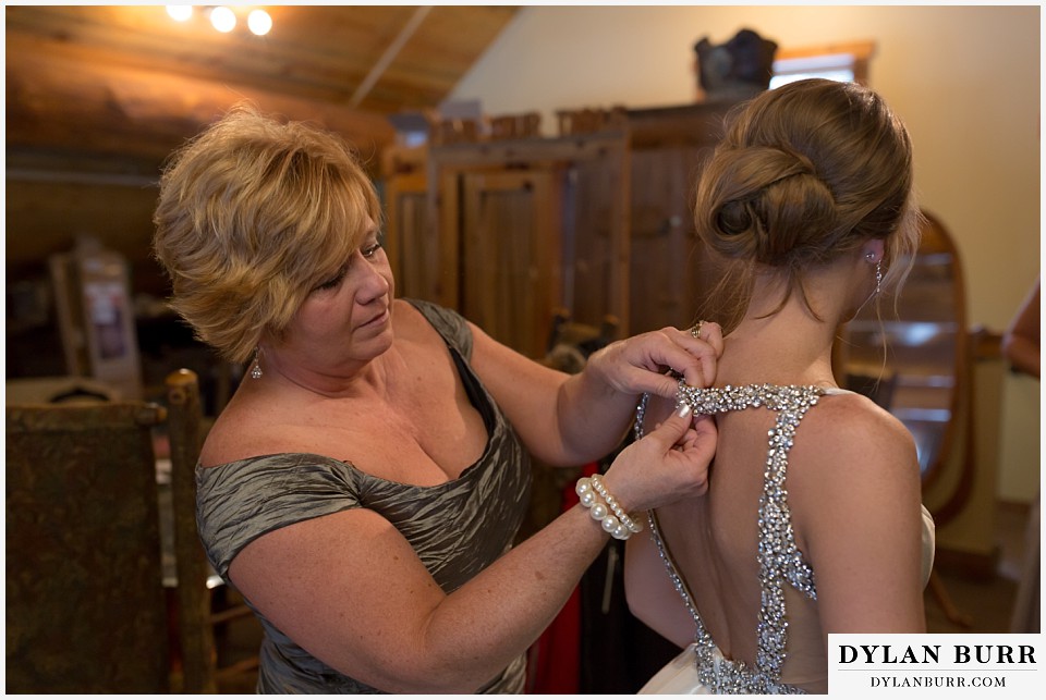 breckenridge nordic center wedding colorado mountain wedding photographer brides mom helping put on dress