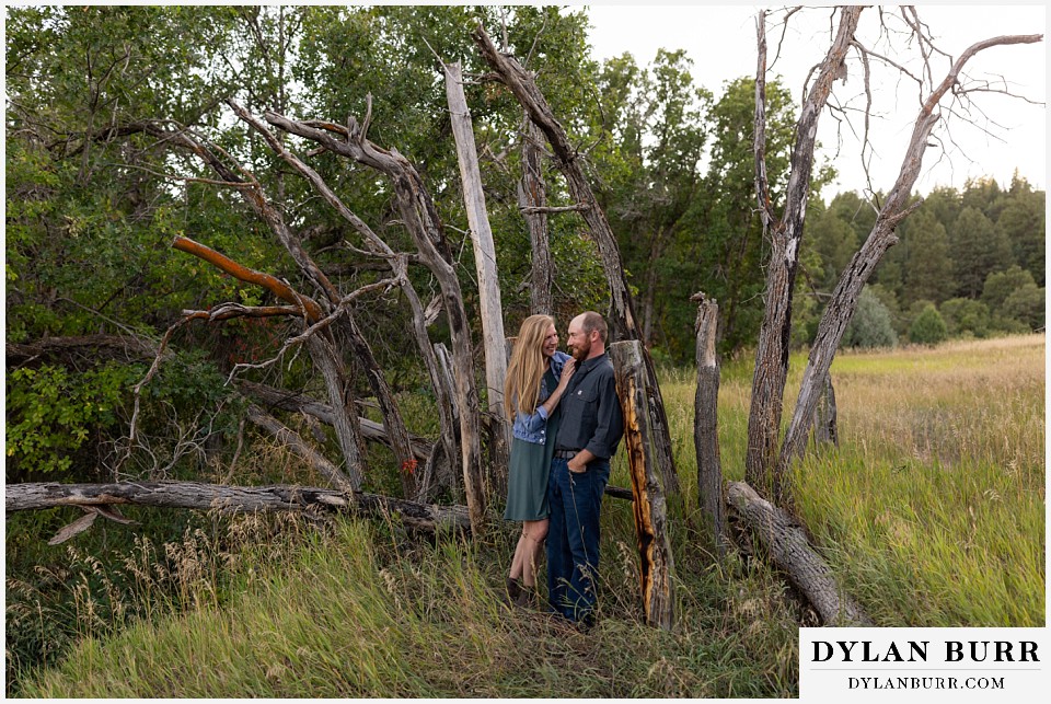 castlewood canyon engagement photos couple standing together near crazy handmade fence