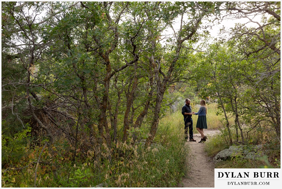castlewood canyon engagement photos wide shot of couple surrounded by small oak trees