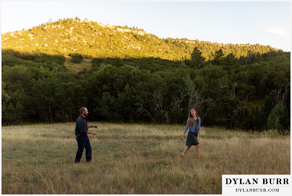 castlewood canyon engagement photos couple playing in field