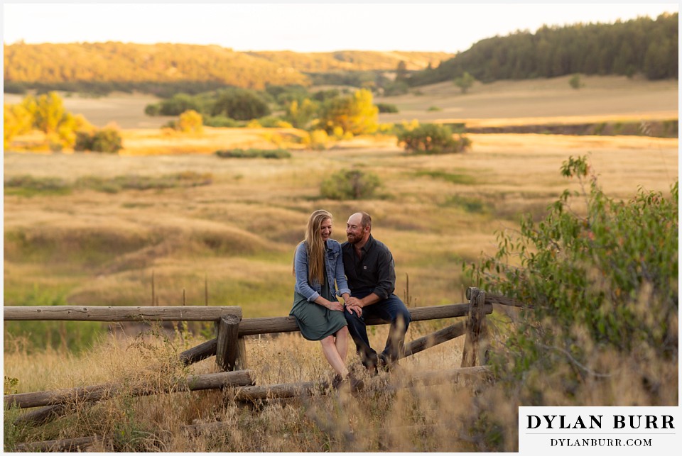 castlewood canyon engagement photos couple together on fence in nature