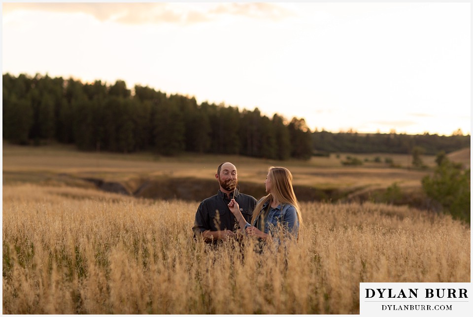 castlewood canyon engagement photos shes trying to tickle his face with a grass sprig