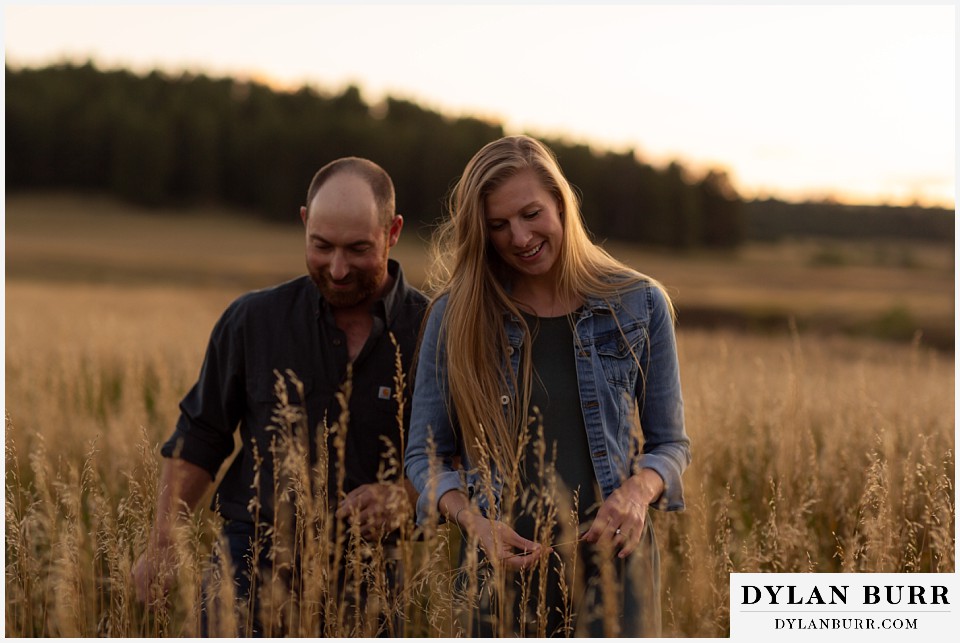 castlewood canyon engagement photos couple walking together out of tall grass