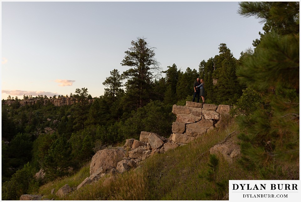 castlewood canyon engagement photos wide view of couple on stone wall