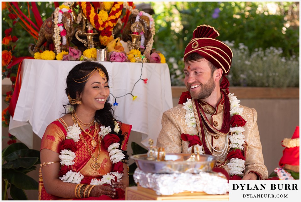 cielo at castle pines wedding colorado mountain wedding bride and groom laughing together under mandap hindu wedding ceremony