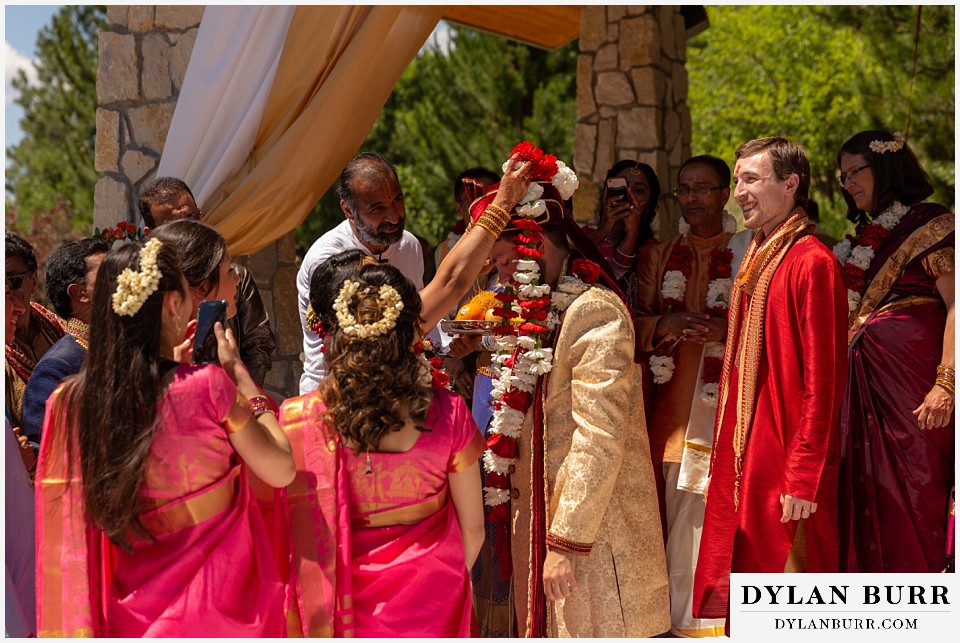 cielo at castle pines wedding colorado mountain wedding bride putting garland on groom hindu ceremony