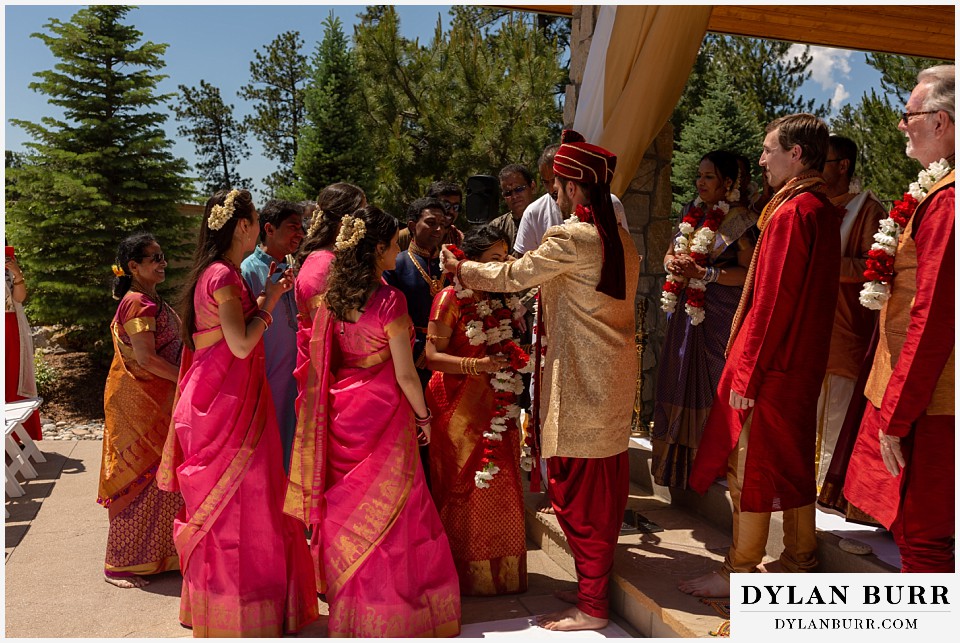 cielo at castle pines wedding colorado mountain wedding groom putting garland on bride hindu wedding ceremony