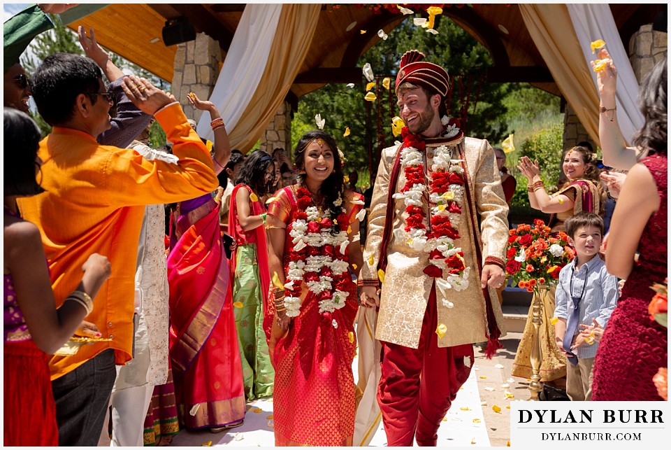 cielo at castle pines wedding colorado mountain wedding bride and groom super happy leaving hindu wedding ceremony mandap
