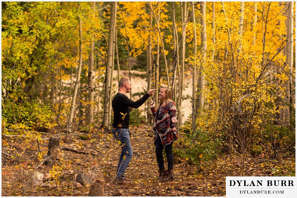 engagement photos in colorado couple showing off dance moves in forest
