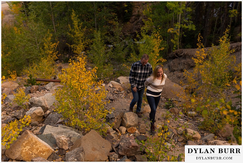engagement photos in colorado couple walking up mountain together