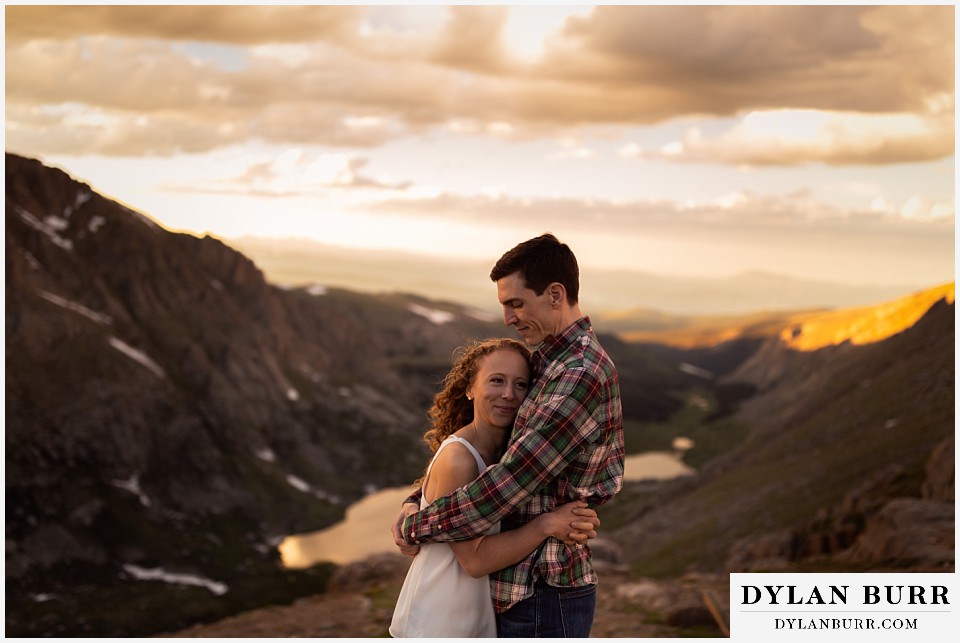 colorado mountain enagagement photo session couple hugging at sunset on mountain peak