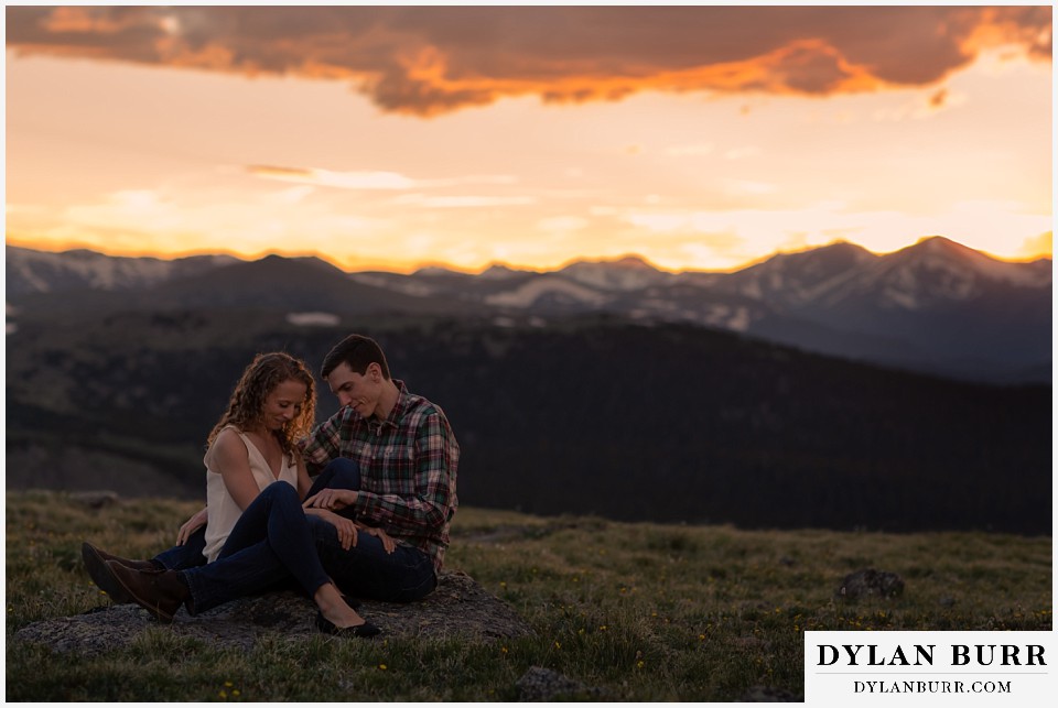 colorado mountain enagagement photo session couple sitting on rock at sunset