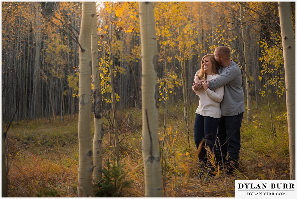 colorado mountain engagement session having a snuggle in the trees