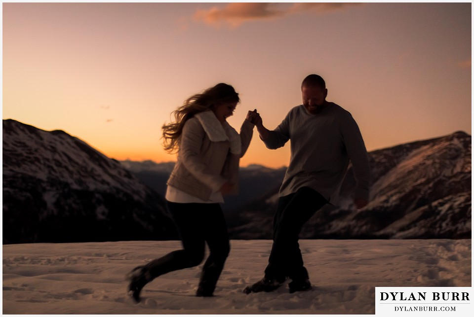 colorado mountain engagement session running in snow on the top of a mountain pass
