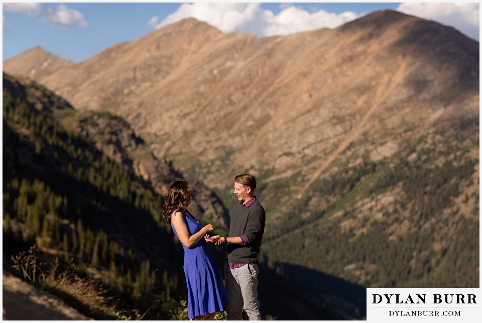 colorado mountain enagagement photos couple standing together in large mountains above tree line