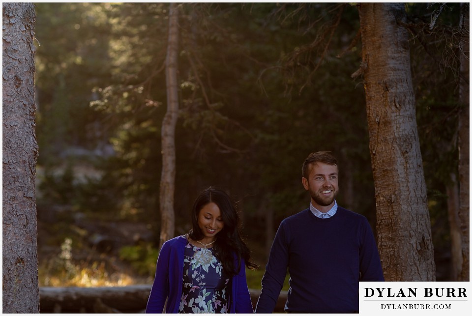 colorado engagement photos in mountains couple walking together in forest