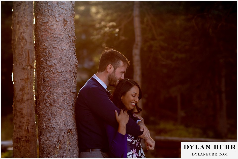 colorado engagement photos in mountains couple together in forest at sunset