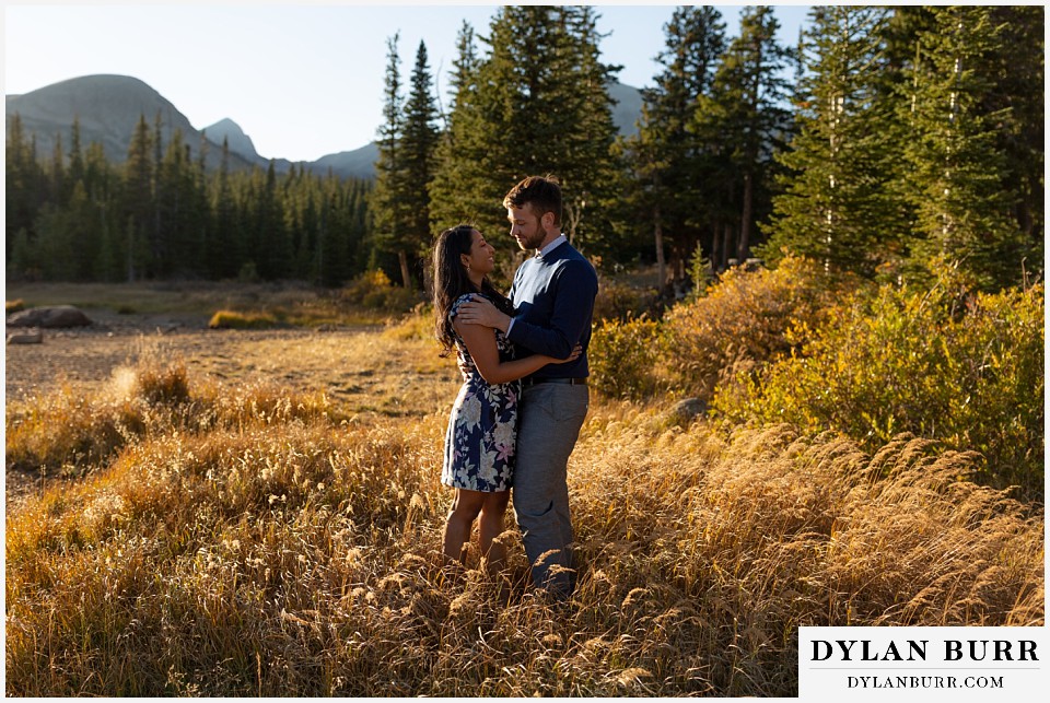 colorado engagement photos in mountains couple standing in tall grass