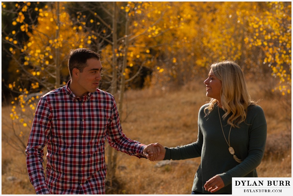 colorado mountain engagement session walking holding hands in yellow aspen trees