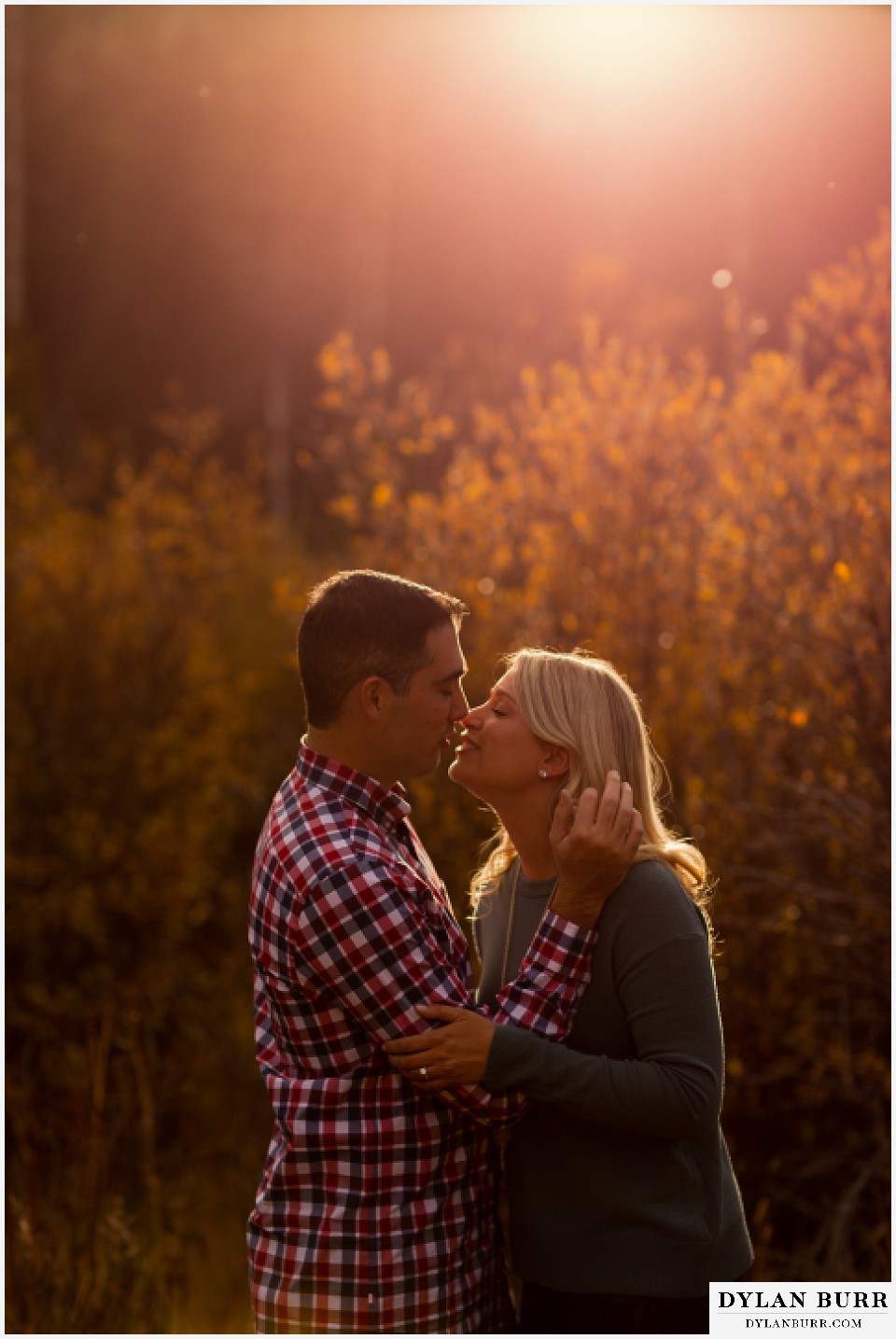 colorado mountain engagement session couple about to kiss surrounded by fall color leaves