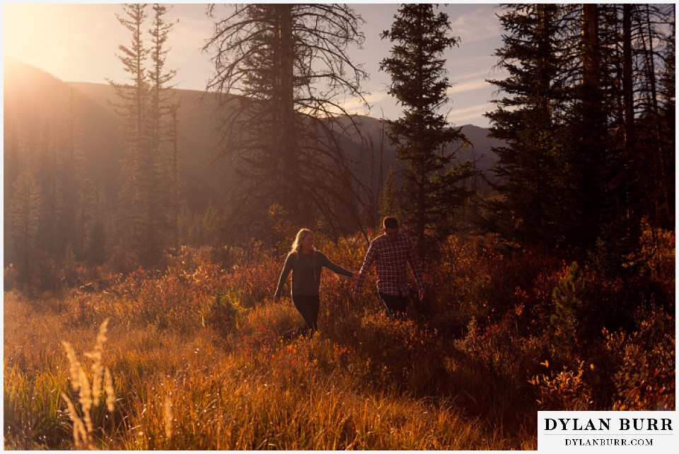colorado mountain engagement session holding hands walking in fall leaves