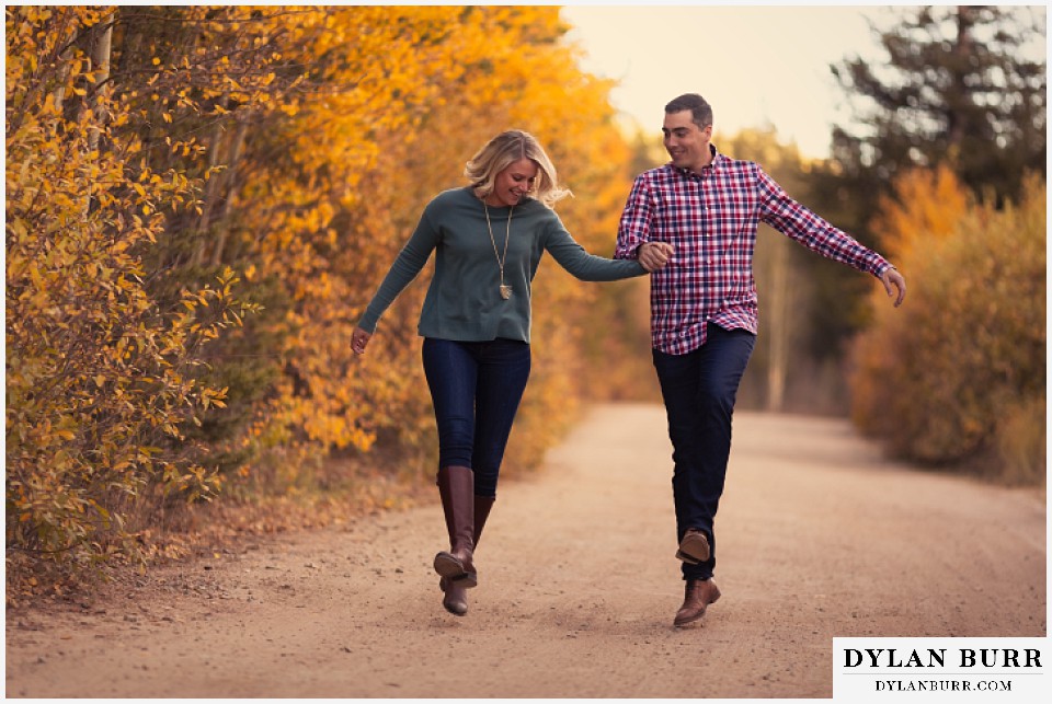 colorado mountain engagement session skipping on fall road