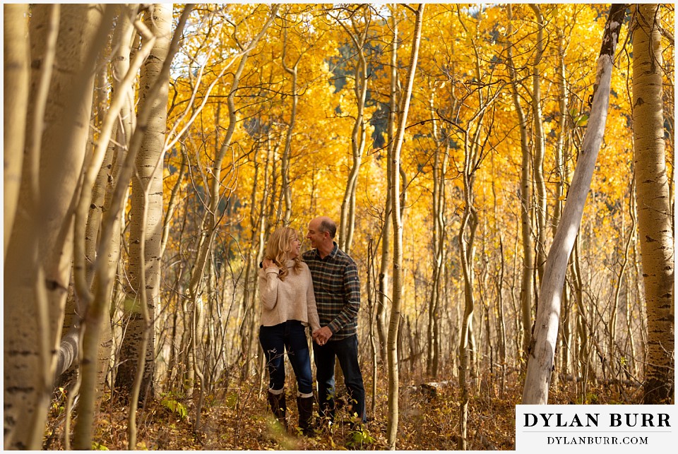 colorado engagement session in mountains couple walking in forest
