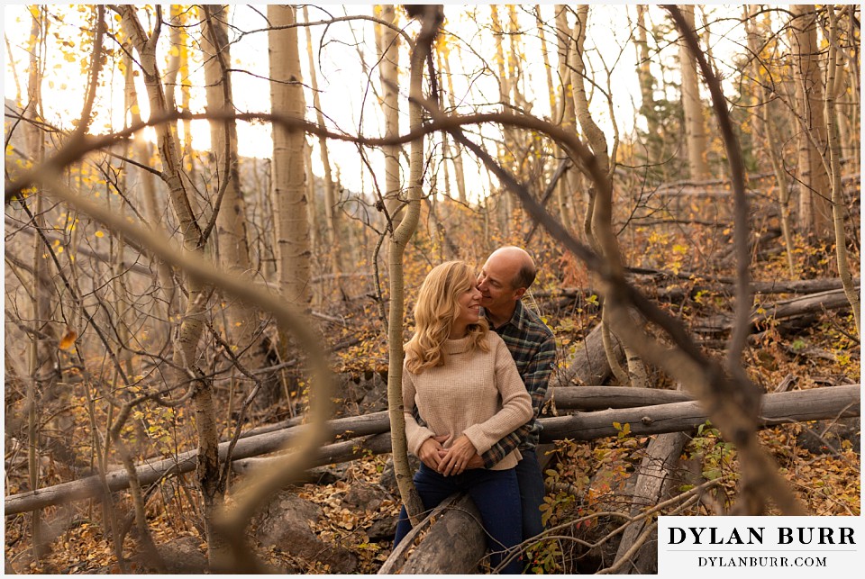 colorado engagement session in mountains couple sitting together on fallen tree