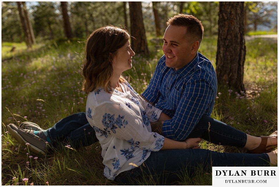 golden colorado mountain enagagement photo session couple sitting in grass in forest