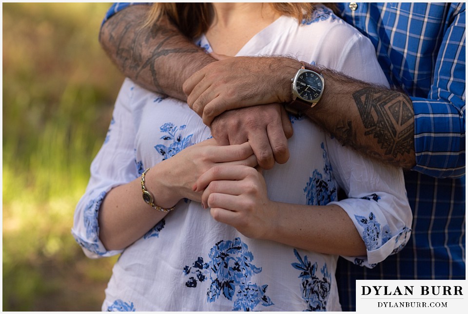 golden colorado mountain enagagement photo session close up details of grooms tattoos and watch