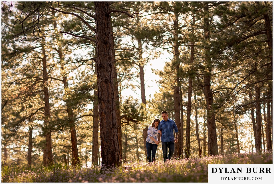 golden colorado mountain enagagement photo session couple walking together and holding each other close