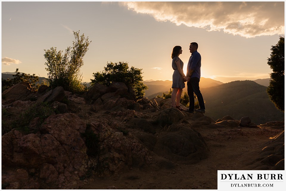 golden colorado mountain enagagement photo session couple standing near each other at sunset