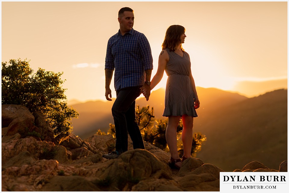 golden colorado mountain enagagement photo session couple at sunset with him looking back