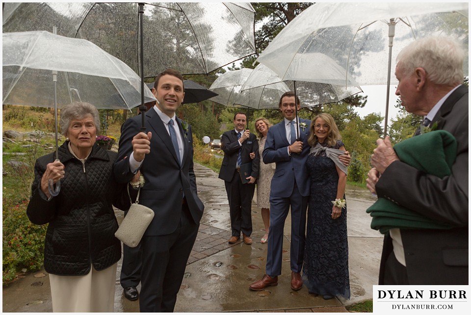 della terra wedding estes park colorado mountain wedding family with umbrellas at rainy ceremony site