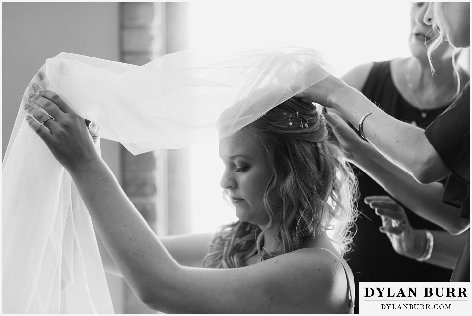 della terra mountain chateau wedding colorado  elopement black and white photo of bride test fitting veil