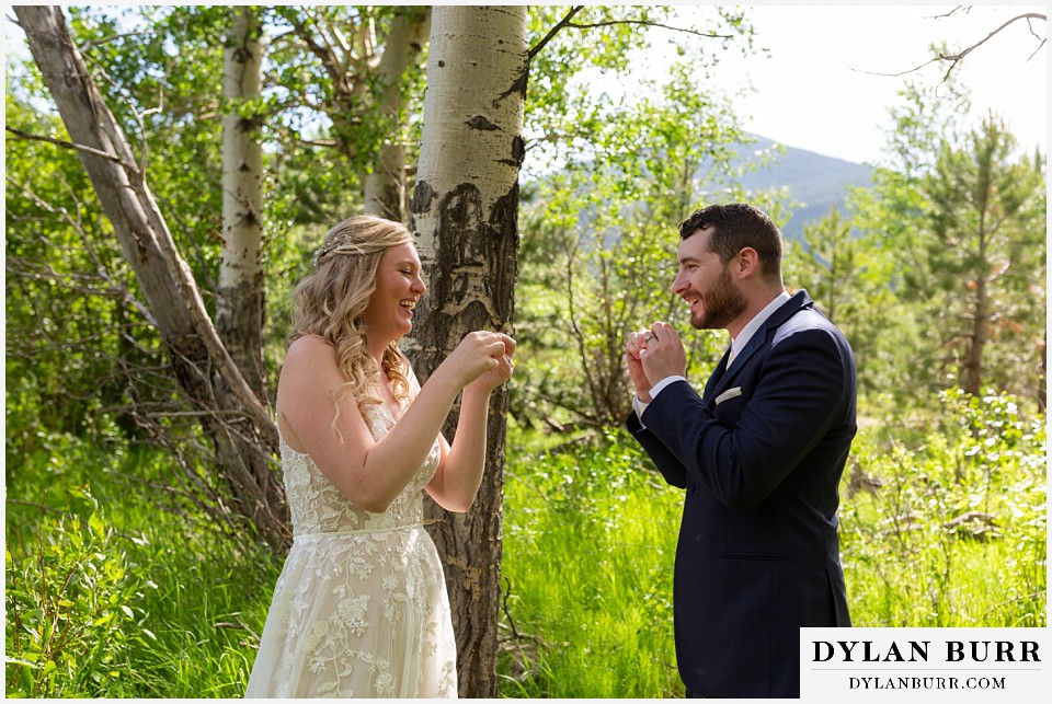 della terra mountain chateau wedding colorado rocky mountain national park wedding rmnp elopement bride and groom trying to make whistles out of leaves