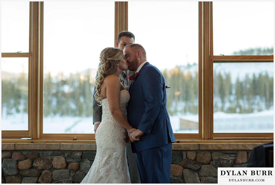 devils thumb ranch wedding in winter ceremony timber house first kiss