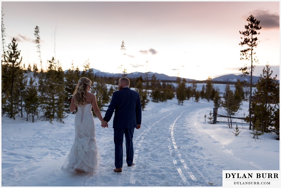 devils thumb ranch wedding in winter newlyweds holding hands